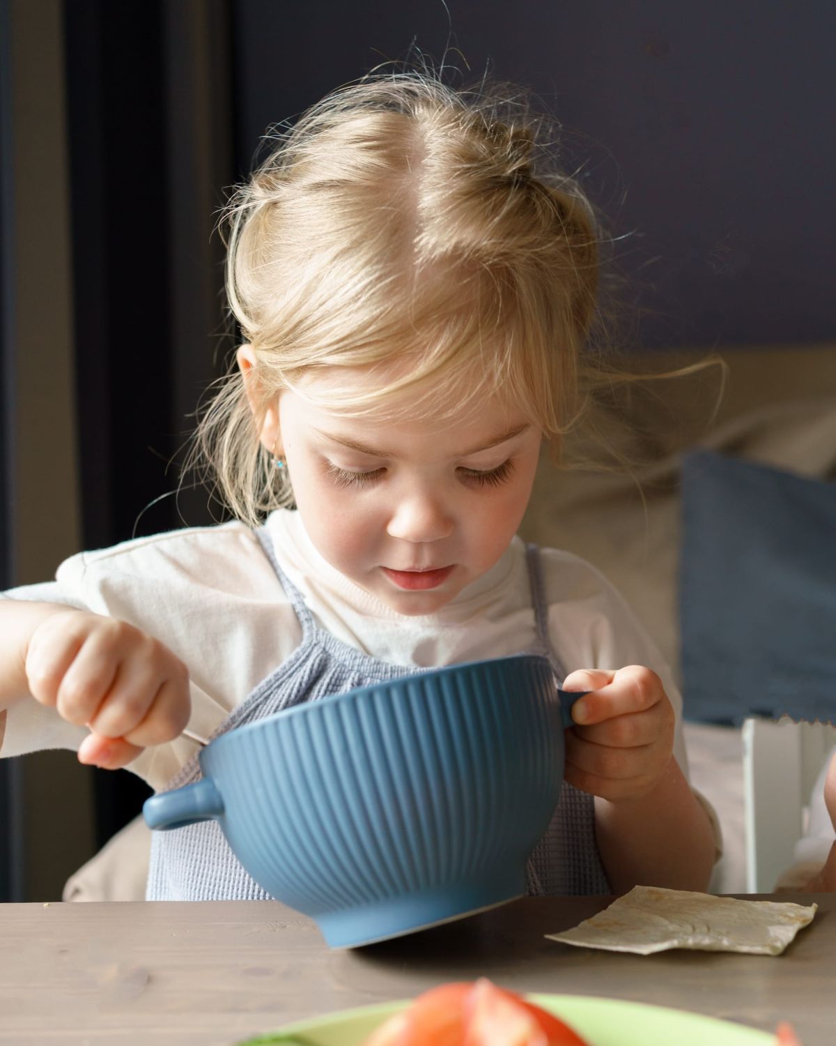Een blond kindje dat verse soep van Soepréme eet